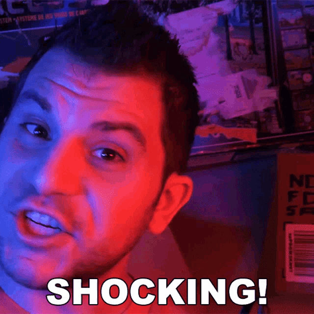 a man is making a shocked face and the word shocking is on the front of his face