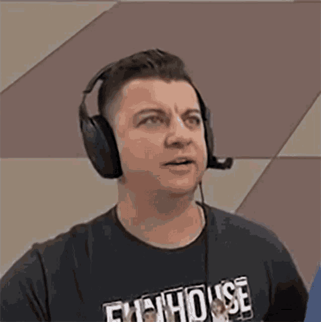 a man wearing headphones and a shirt that says " fuckhouse " on it