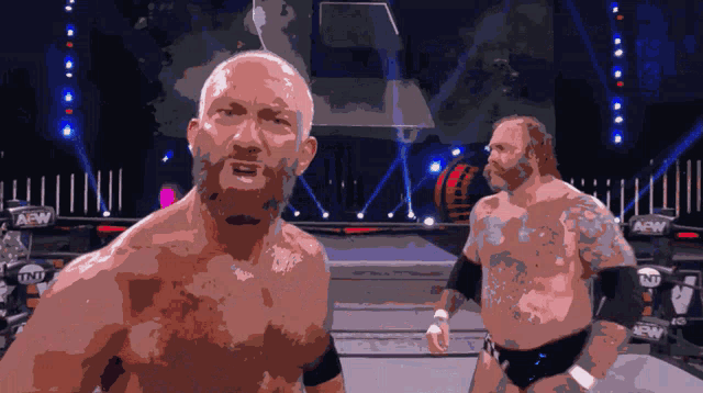 two wrestlers are standing in a ring with aaw written on the side