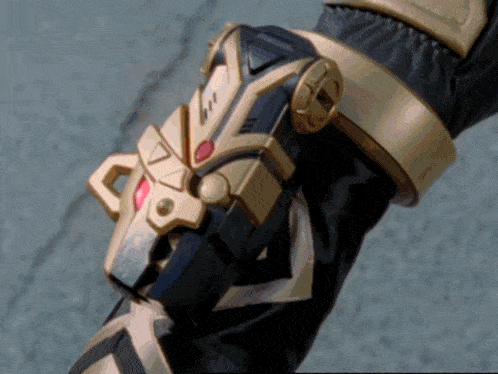 a close up of a person 's arm with a gold and black device on it