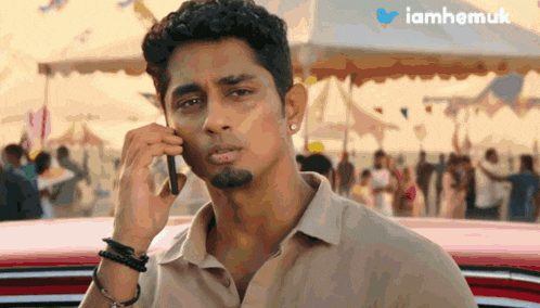 a man is talking on a cell phone with a twitter logo in the corner