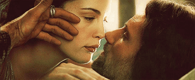 a man with a ring on his finger kisses a woman on the nose