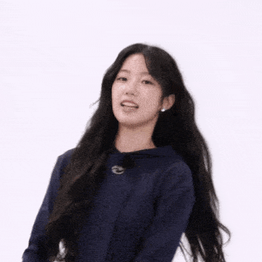 a woman in a blue hoodie is holding her hair up