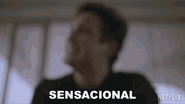 a blurred image of a man with the word sensacional written in white
