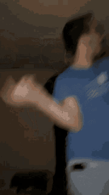 a blurry picture of a man wearing a blue shirt that says ' texas ' on it