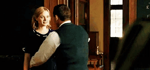a man and a woman are dancing in a room .