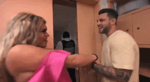 a man and a woman are standing next to each other in a room .