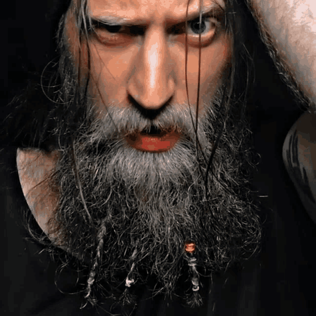 a man with a long beard has a red lip