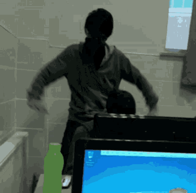 a man is standing in front of a computer screen with the windows logo on it