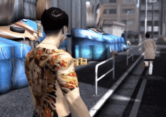 a man with a tattoo on his back walking down a street