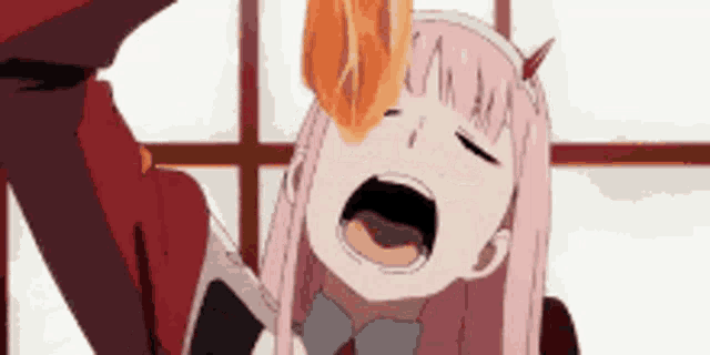 a girl with pink hair and horns is eating a piece of food .