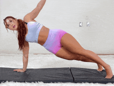 a woman is doing a plank on a mat