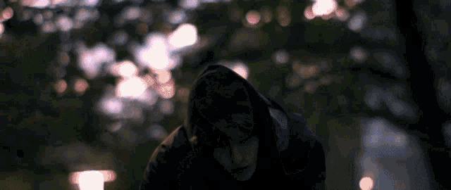 a blurred image of a person in a dark room with a pink light behind them