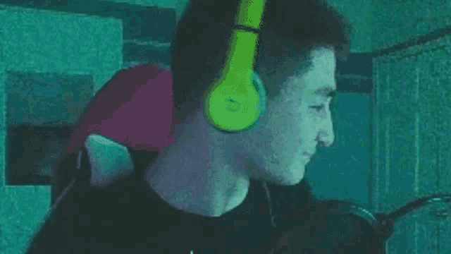 a man wearing headphones is sitting in a chair and looking at something .