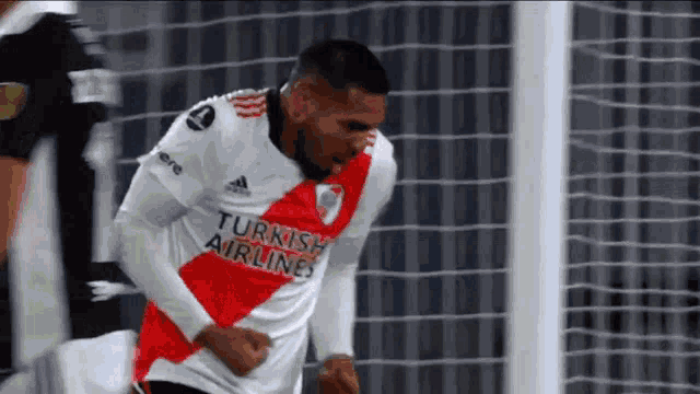 a soccer player wearing a turkish airlines jersey is celebrating a goal