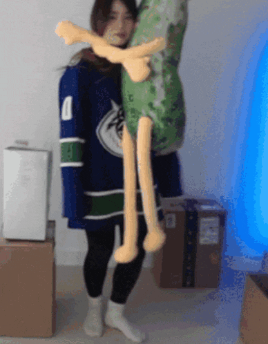 a woman in a vancouver canucks jersey holds a large stuffed animal