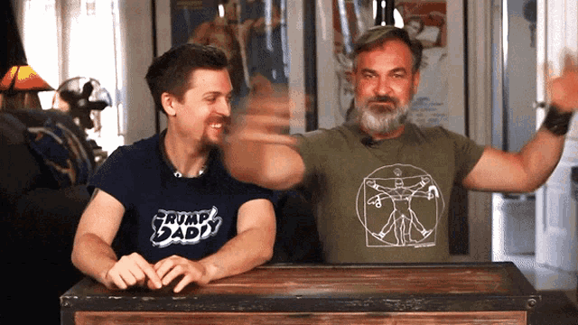 a man wearing a shirt that says trump daddy is standing next to another man