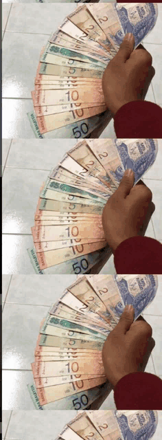 a person is holding a fan of canadian money in their hand