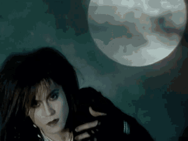 a woman with a full moon in the background