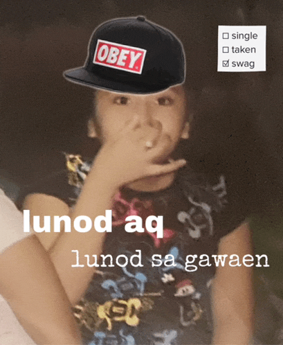a boy wearing an obey hat holds his nose