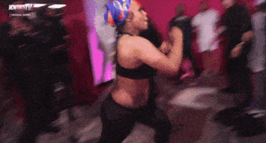 a woman is dancing in front of a crowd with the words nowthistv on the bottom right