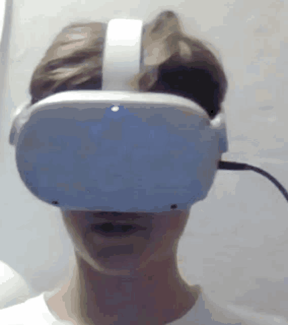 a man wearing a virtual reality headset is making a face .