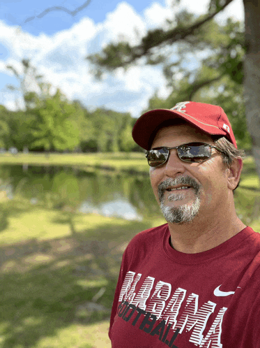 a man wearing sunglasses and a red shirt that says alabama football
