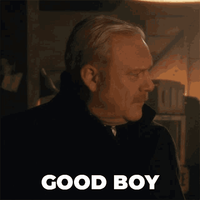 a man with a mustache says good boy in white letters
