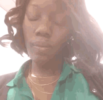 a woman wearing a green shirt and a gold chain around her neck