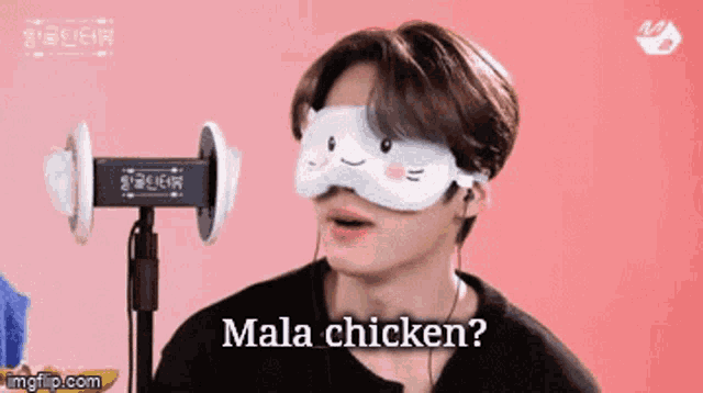 a man wearing a cat mask and earphones says mala chicken