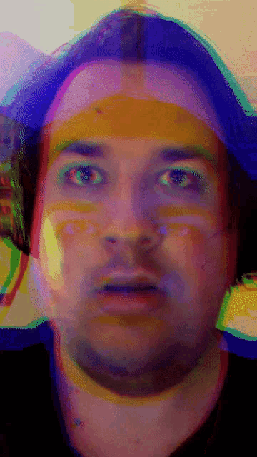 a blurry picture of a man 's face with a purple and yellow background