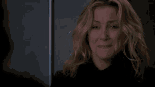 a woman is crying with her eyes closed and a black shirt on .