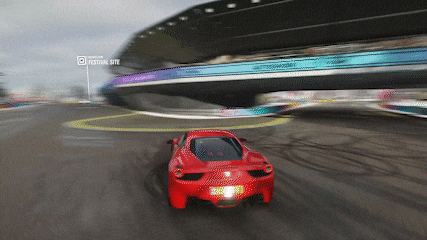 a red sports car is driving on a race track with a sign that says festival site in the background