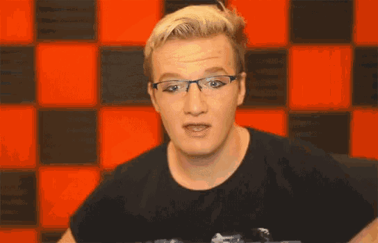 a young man wearing glasses is making a funny face