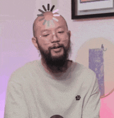 a man with a beard and glasses is wearing a white t-shirt with the letter g on it