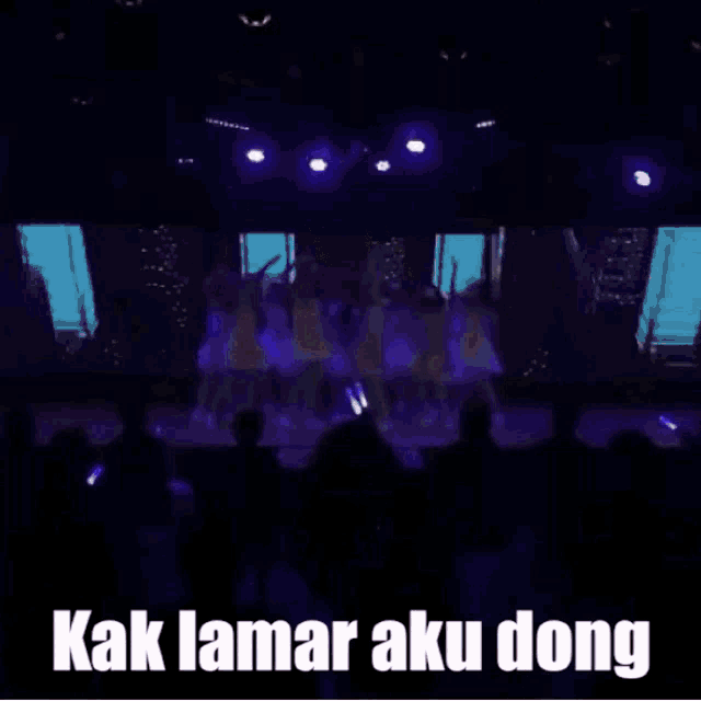 a woman is singing into a microphone with the words kak lamar aku bong written below her