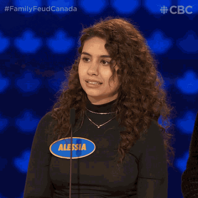 a woman with a name tag that says alessia smiles in front of a microphone