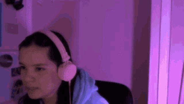 a young girl wearing headphones is sitting in front of a computer .