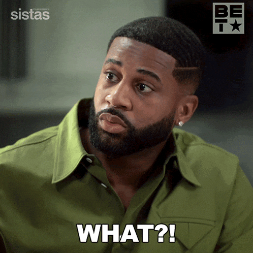 a man in a green shirt has the word what on his face