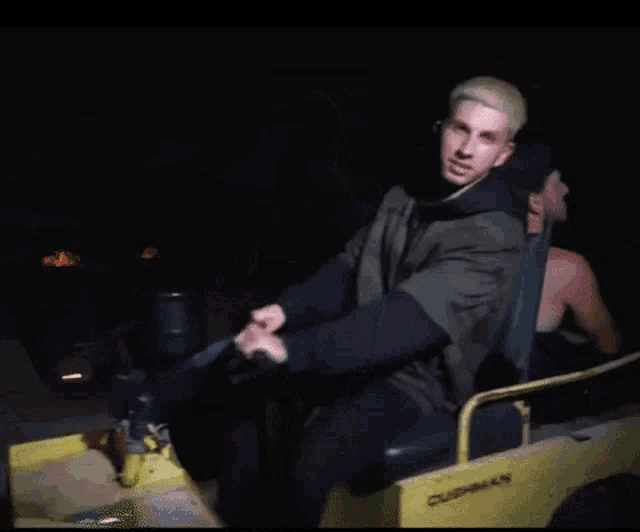 two men are sitting on a cushman vehicle