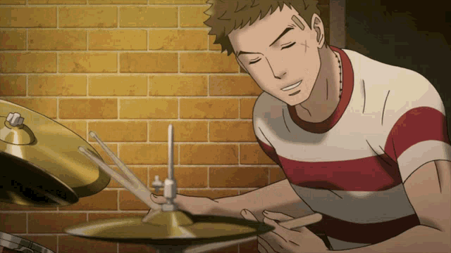 a man in a striped shirt is playing drums