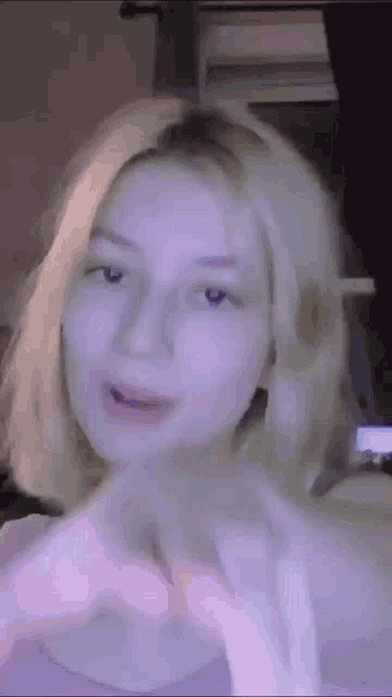 a close up of a woman 's face with purple background
