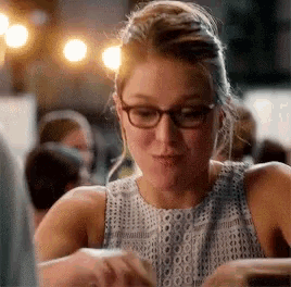 a close up of a woman wearing glasses and a sleeveless top
