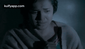 a woman is crying in a dark room with the words kulfyapp.com visible in the corner