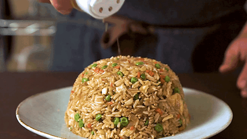 Adding Sesame Seeds On Top Of Fried Rice Two Plaid Aprons GIF