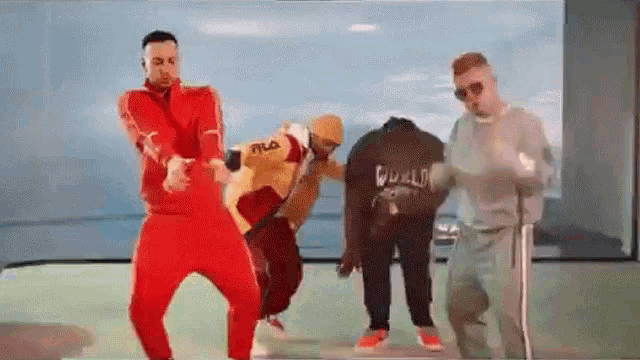 a group of men are dancing together in a video .