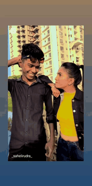 a man in a black shirt and a woman in a yellow top pose for a picture
