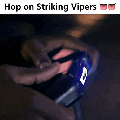 a man sits on a couch looking at a cell phone with the caption hop on striking vipers