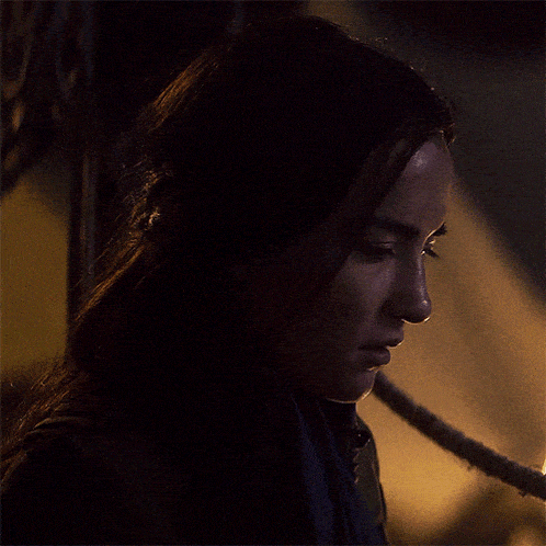 a close up of a woman 's face with a rope in the foreground