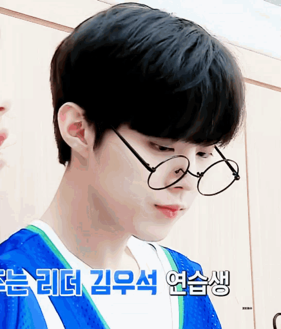 a close up of a person wearing glasses and a blue shirt